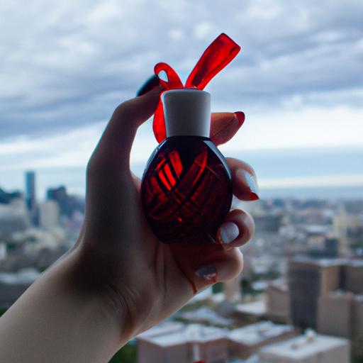 Người mẫu cầm chai nước hoa Good Girl Đỏ trước tầm nhìn thành phố.