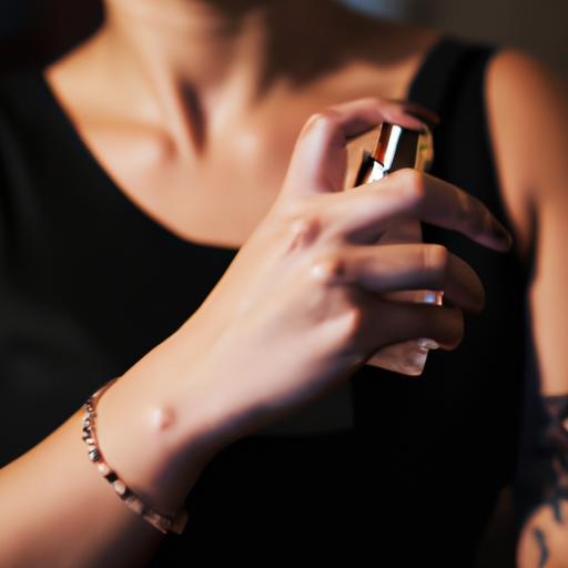 Một tấm chụp cận cảnh phụ nữ xịt nước hoa Acqua Di Gio vào cổ tay. Phụ nữ có biểu cảm nghiêm túc và đang mặc một chiếc váy đen.